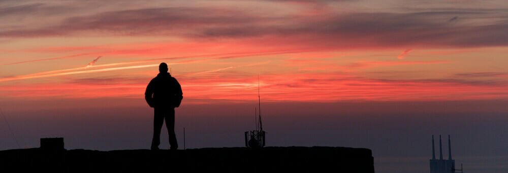 Silhouette of a man enjoying the view of a beautiful sunset. 